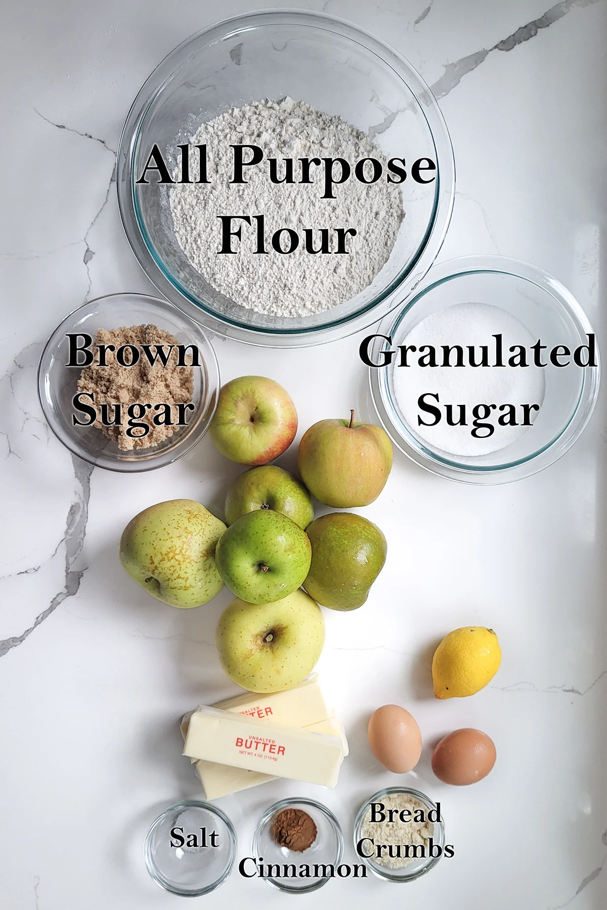 ingredients for dutch apple tart in glass bowls on a white surface.