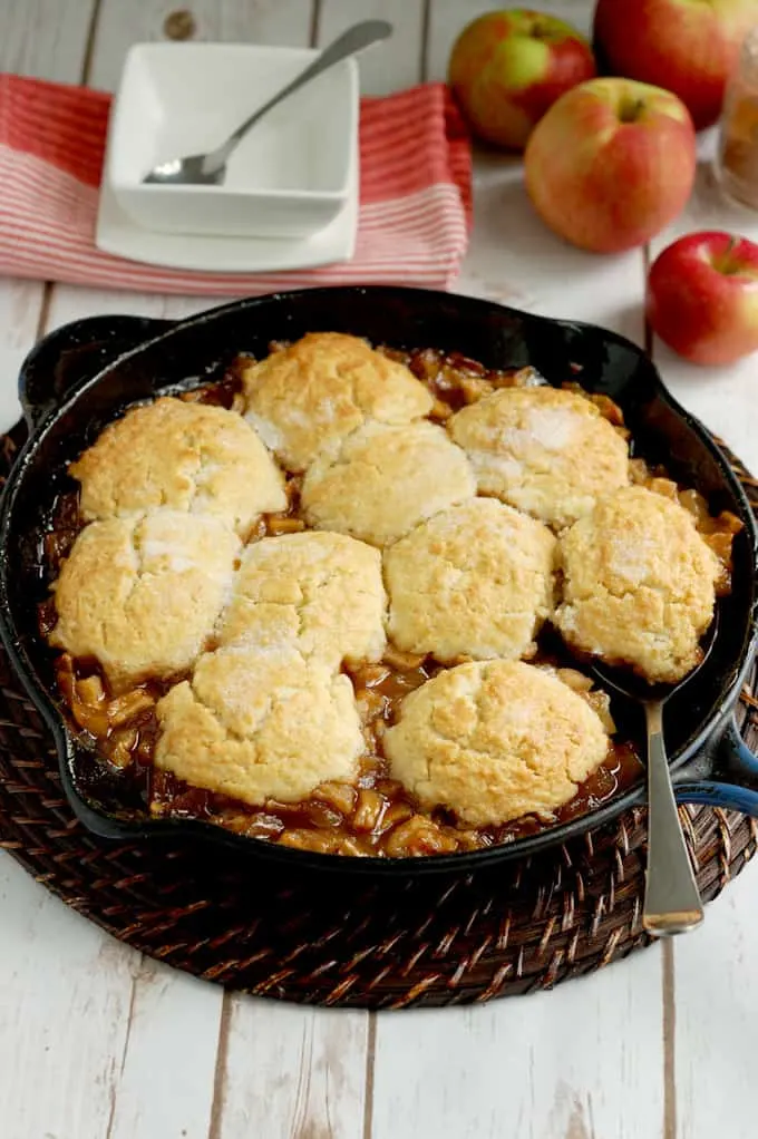 a cast iron skillet with biscuit topped apple cobbler