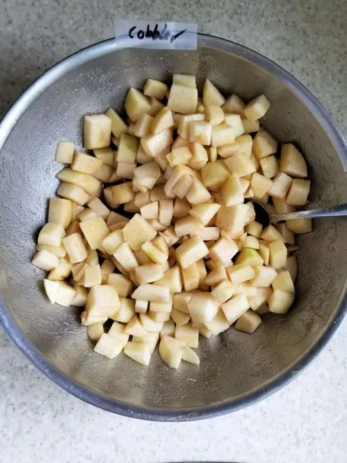 a bowl of chopped apples with sugar and cinnamon
