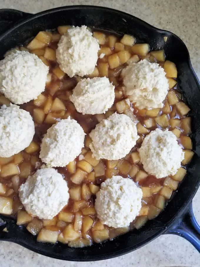 apple cobbler with biscuit dough ready to go into the oven