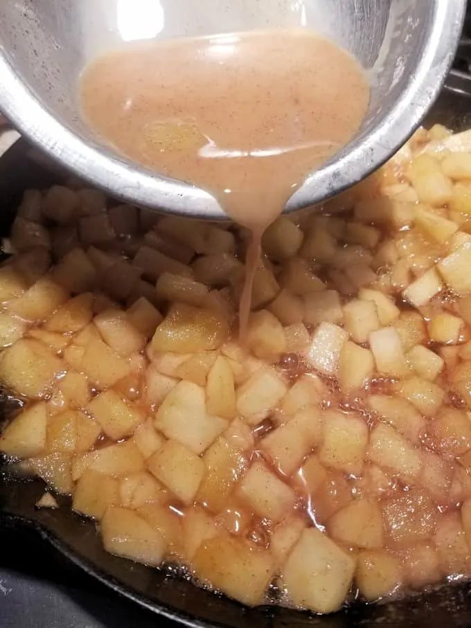 apples cooking in a cast iron skillet