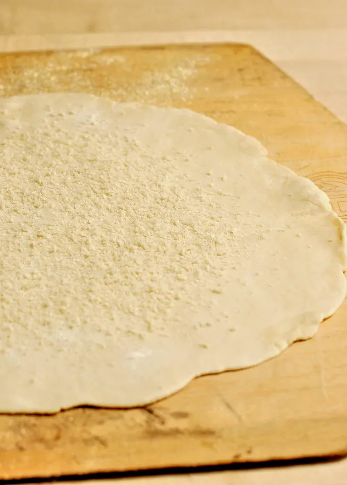 a round of pie dough on a pizza peel.