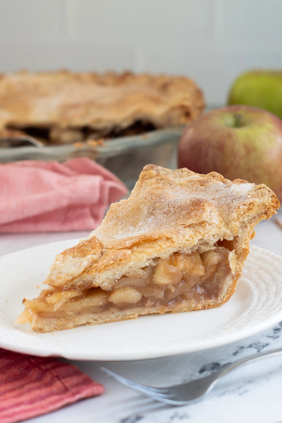 a slice of apple pie on a white plate.