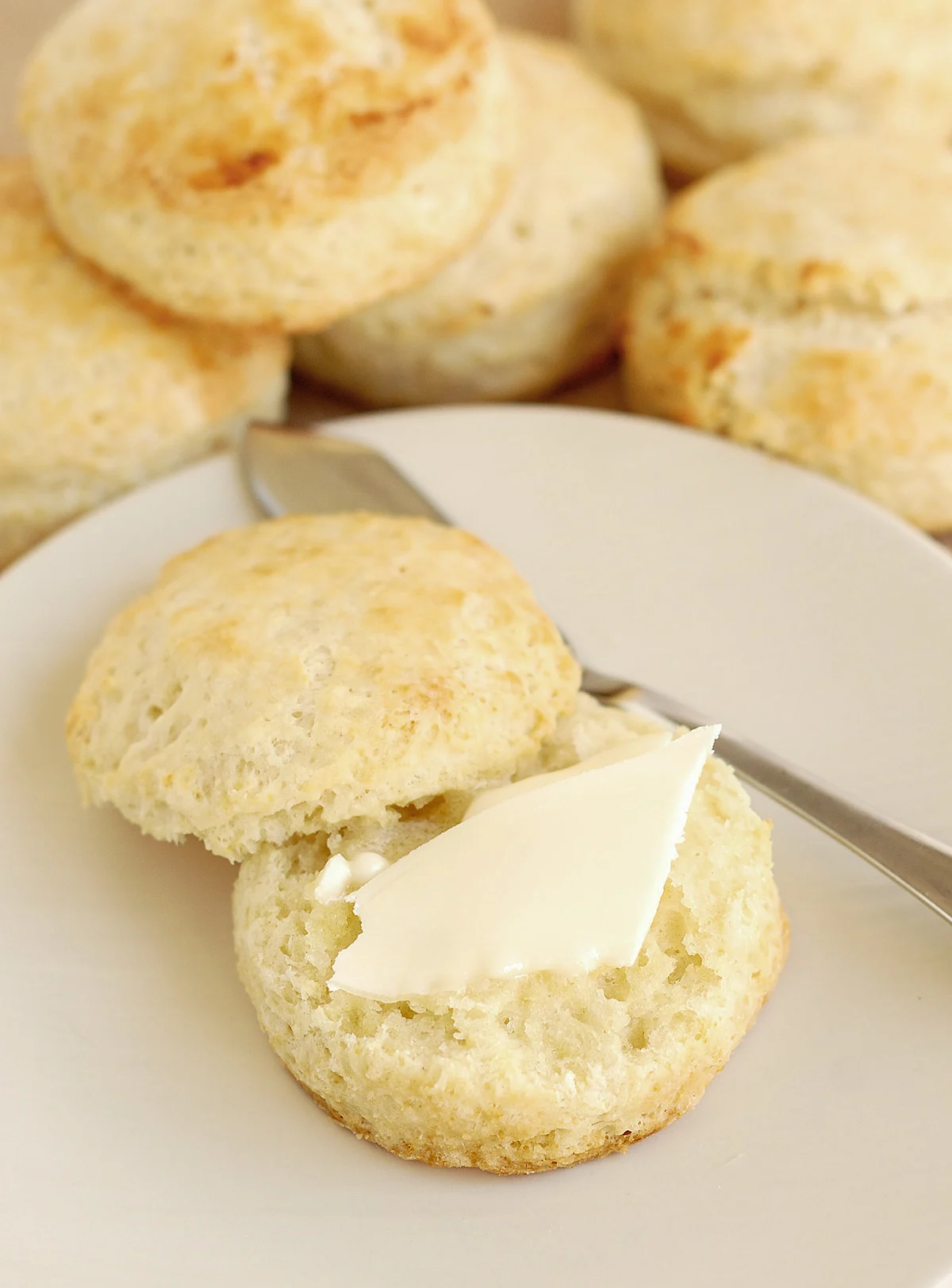 a split biscuit on a plate with butter.