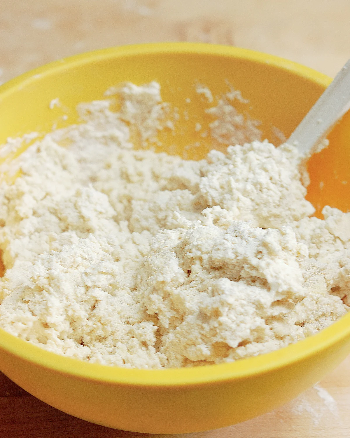 a bowl of biscuit dough with a spatula.