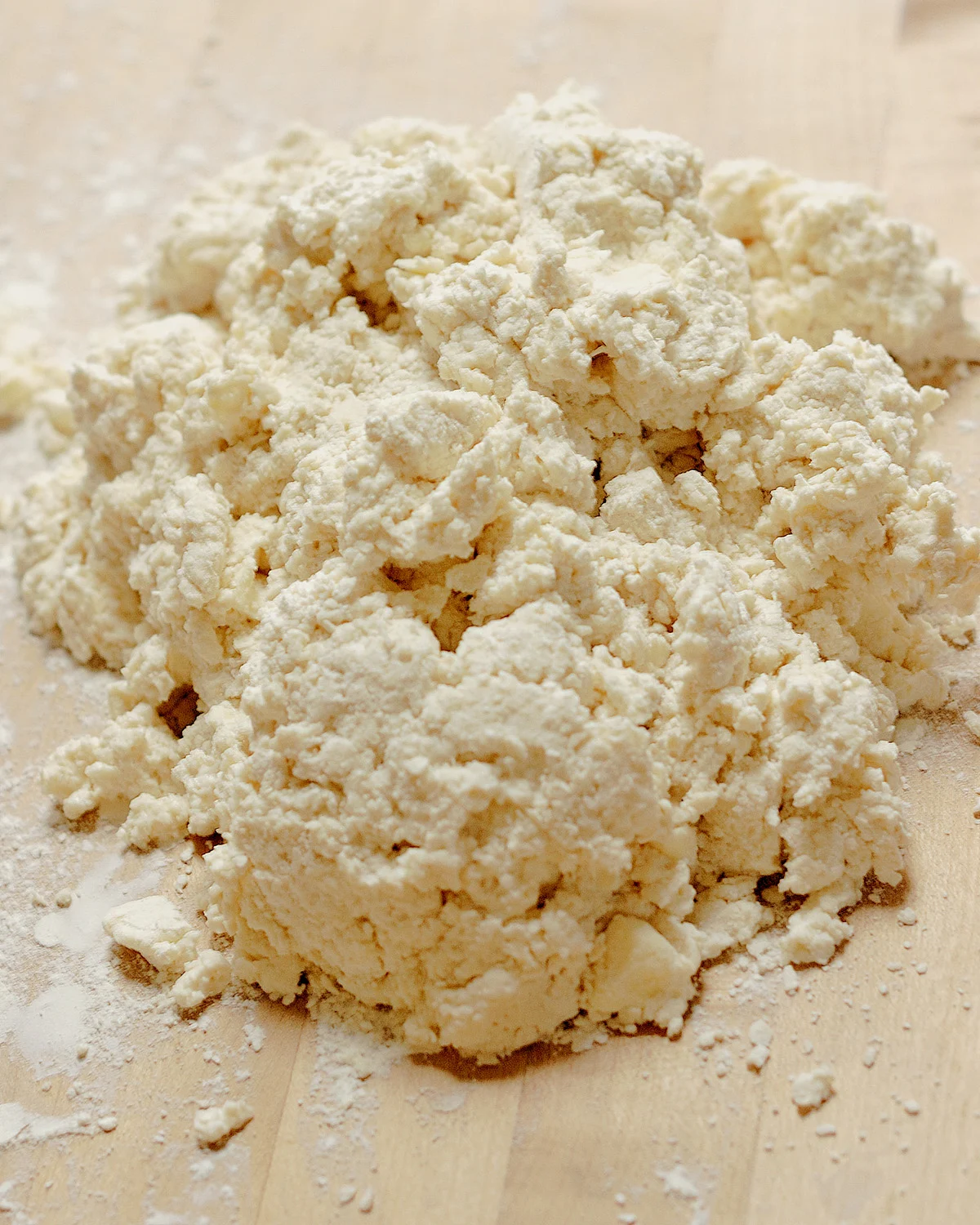 a pile of loose biscuit dough on a wooden surface.