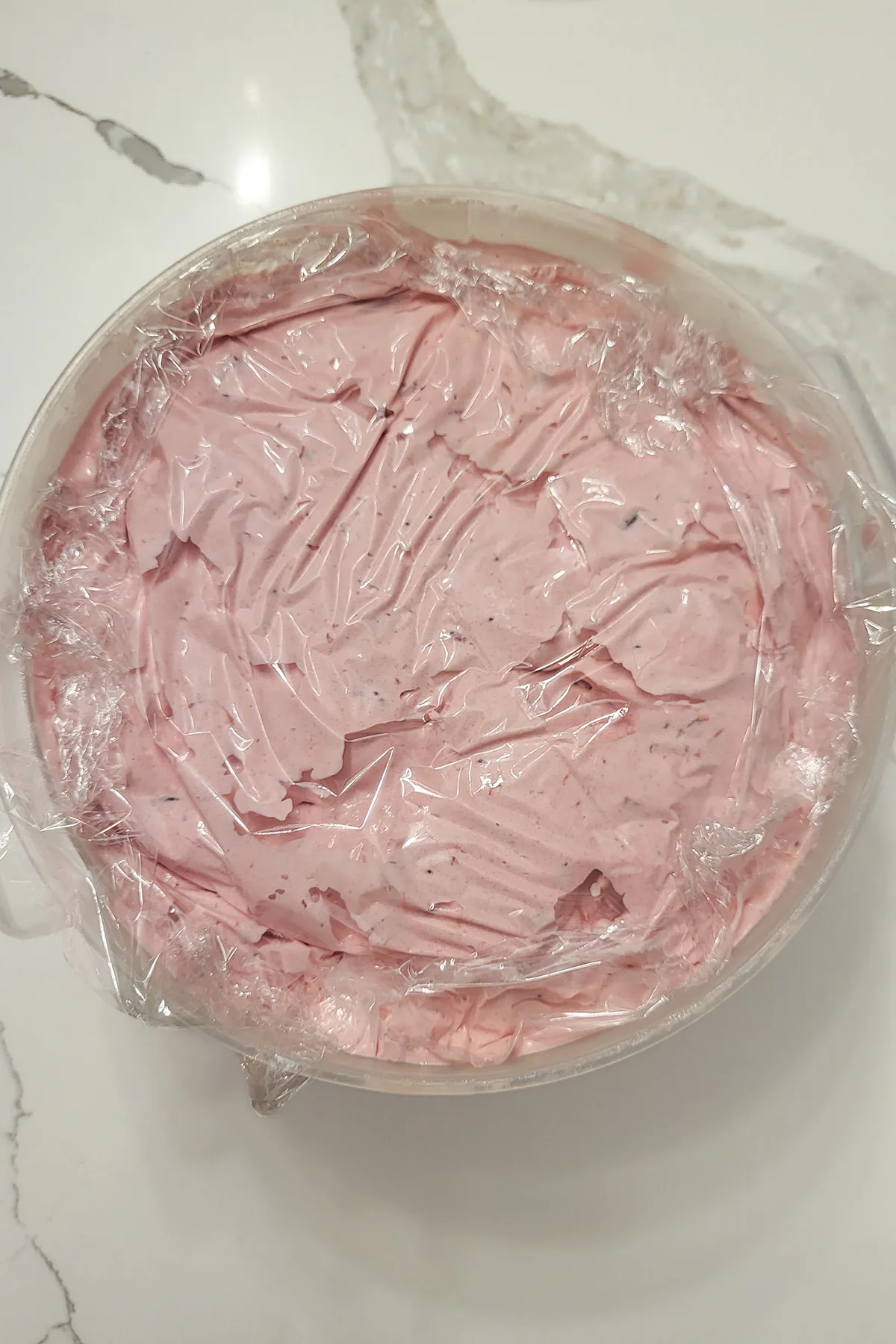 a plastic bucket of cranberry ice cream.