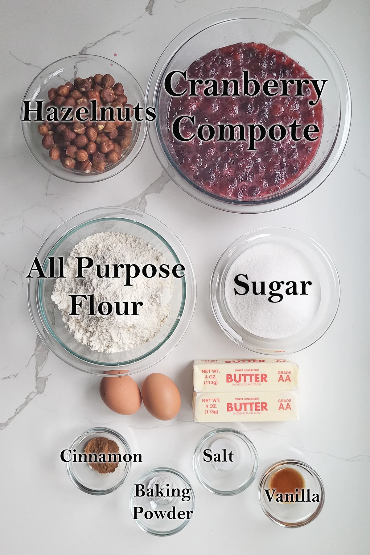 ingredients for cranberry linzer tart in glass bowls on a white surface.