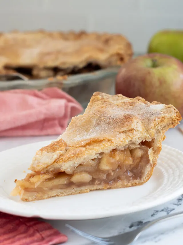 a slice of apple pie on a white plate.