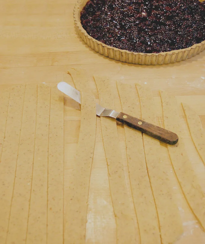 strips of dough on a butcher block surface.