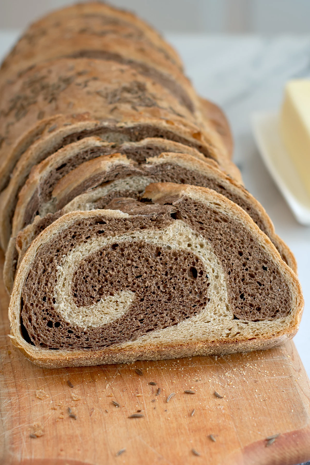 a sliced loaf of marble rye bread on a cutting board.