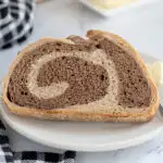 a slice of marble rye bread on a white plate.