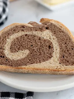 a slice of marble rye bread on a white plate.