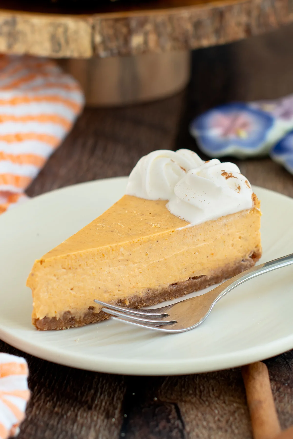 a slice of pumpkin cheesecake on a white plate.