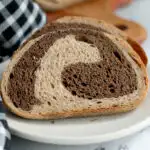 a slice of sourdough marble rye bread on a white plate.