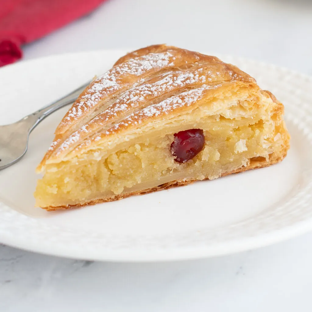 a slice of galette des rois on a white plate.