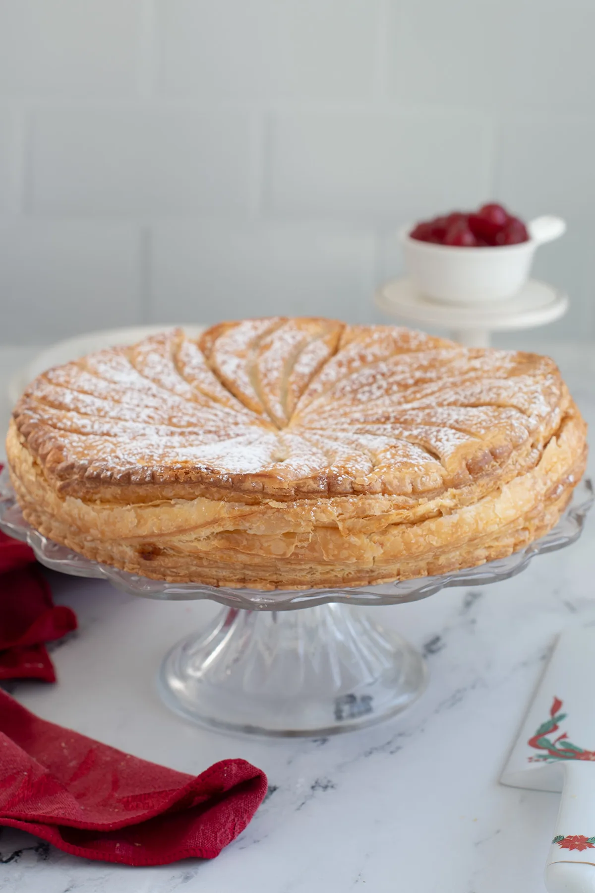 a puff pastry cake on a glass stand.