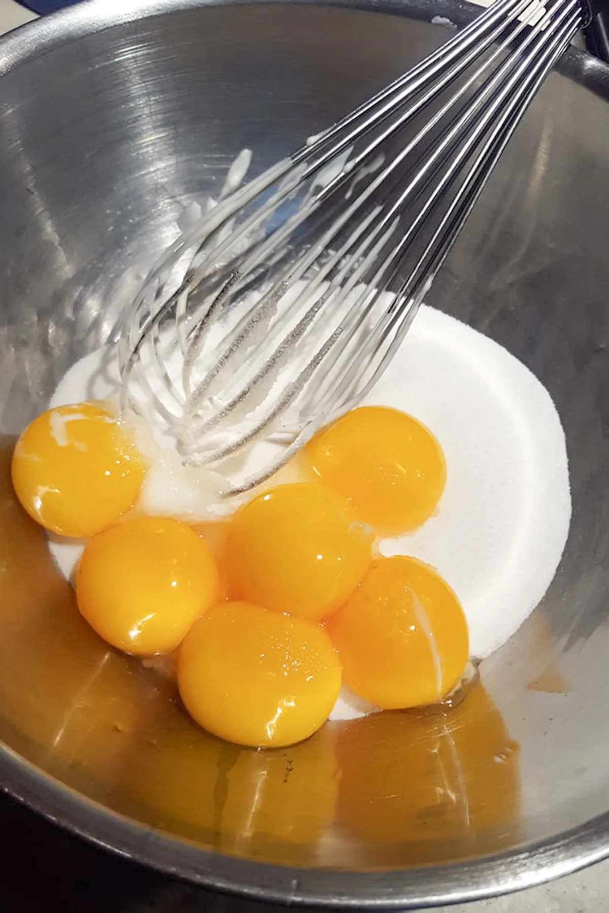 egg yolks and sugar in a bowl with a whisk.