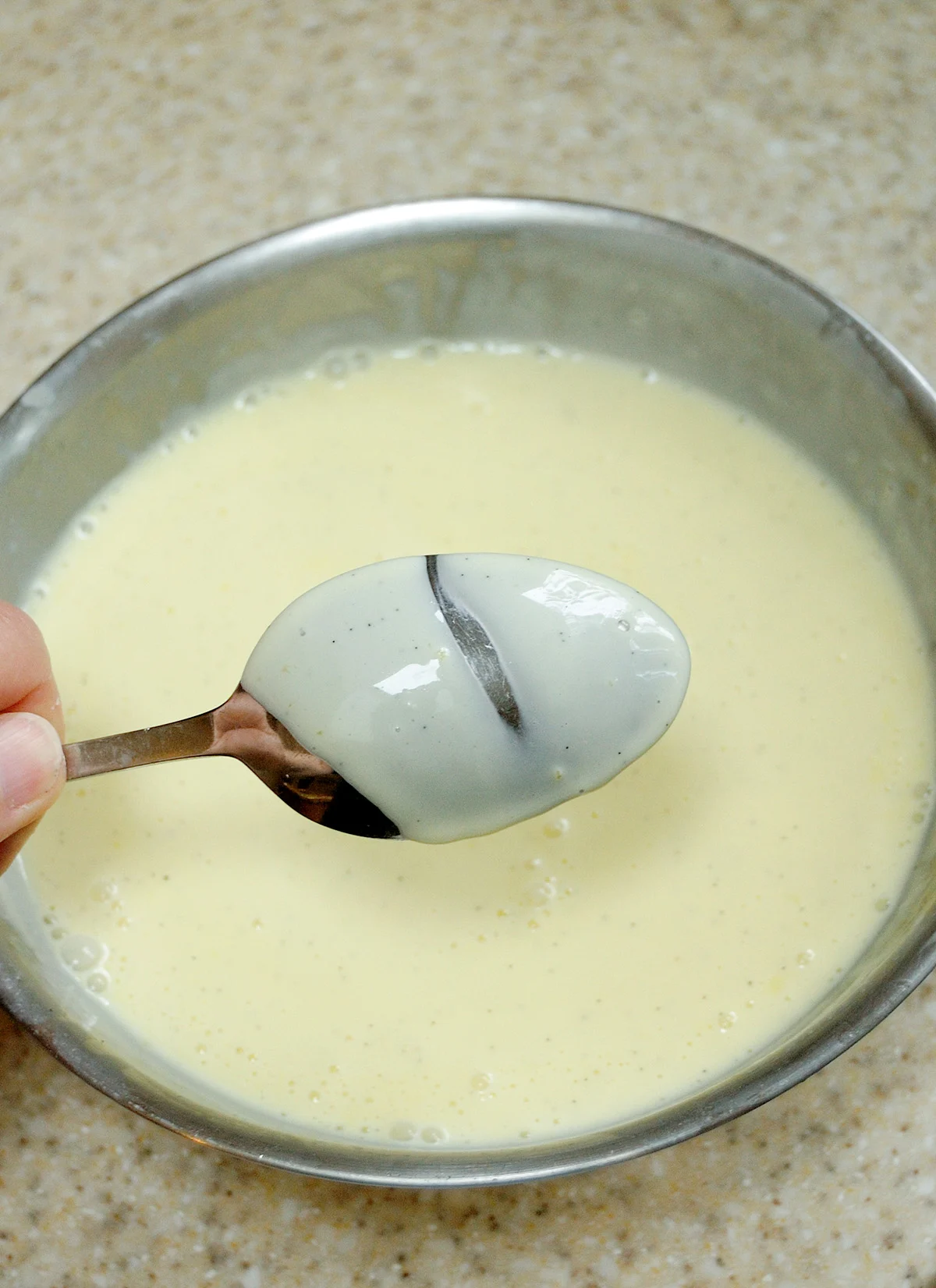 Custard sauce coating a spoon.