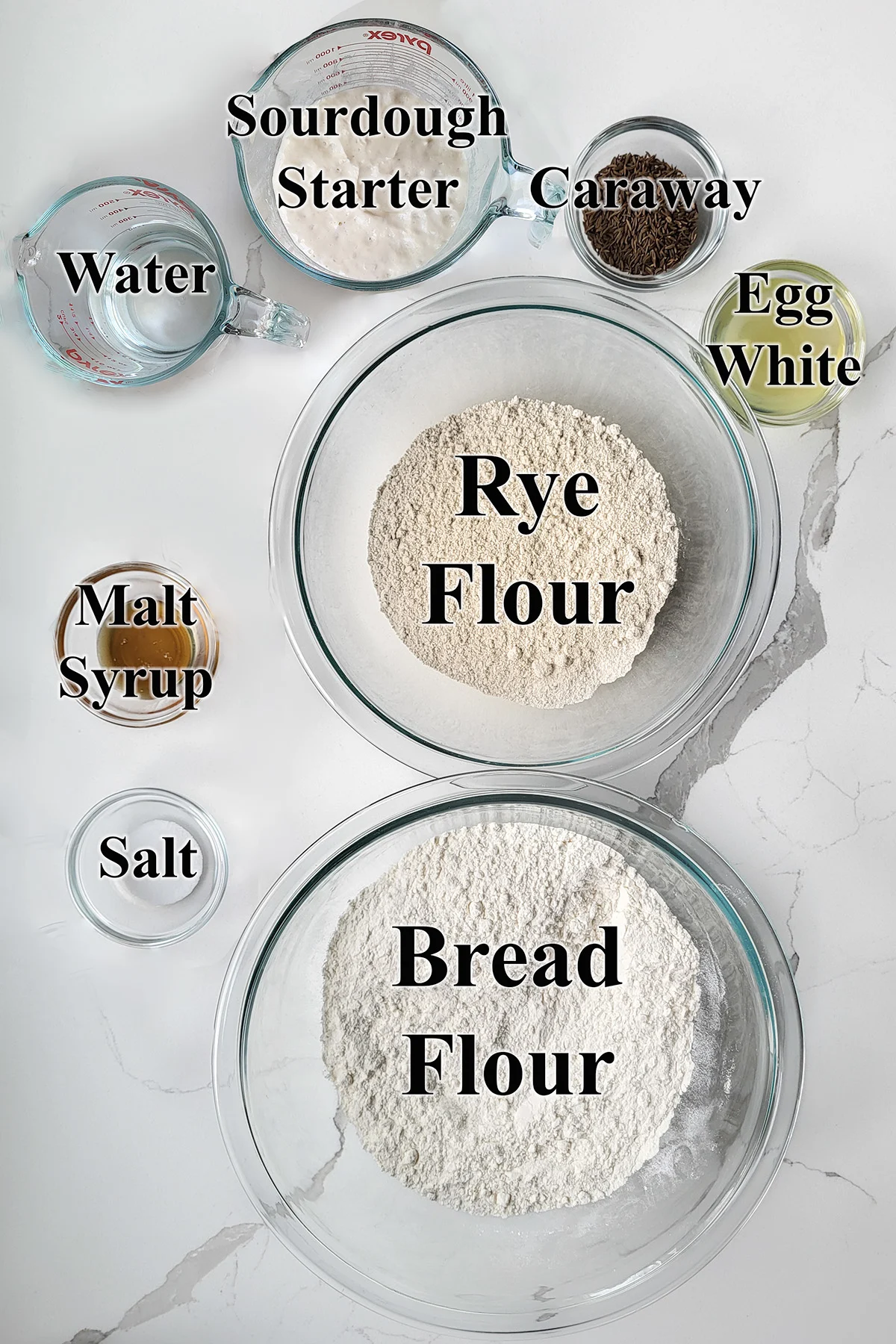 Ingredients for sourdough rye bread in glass bowls.