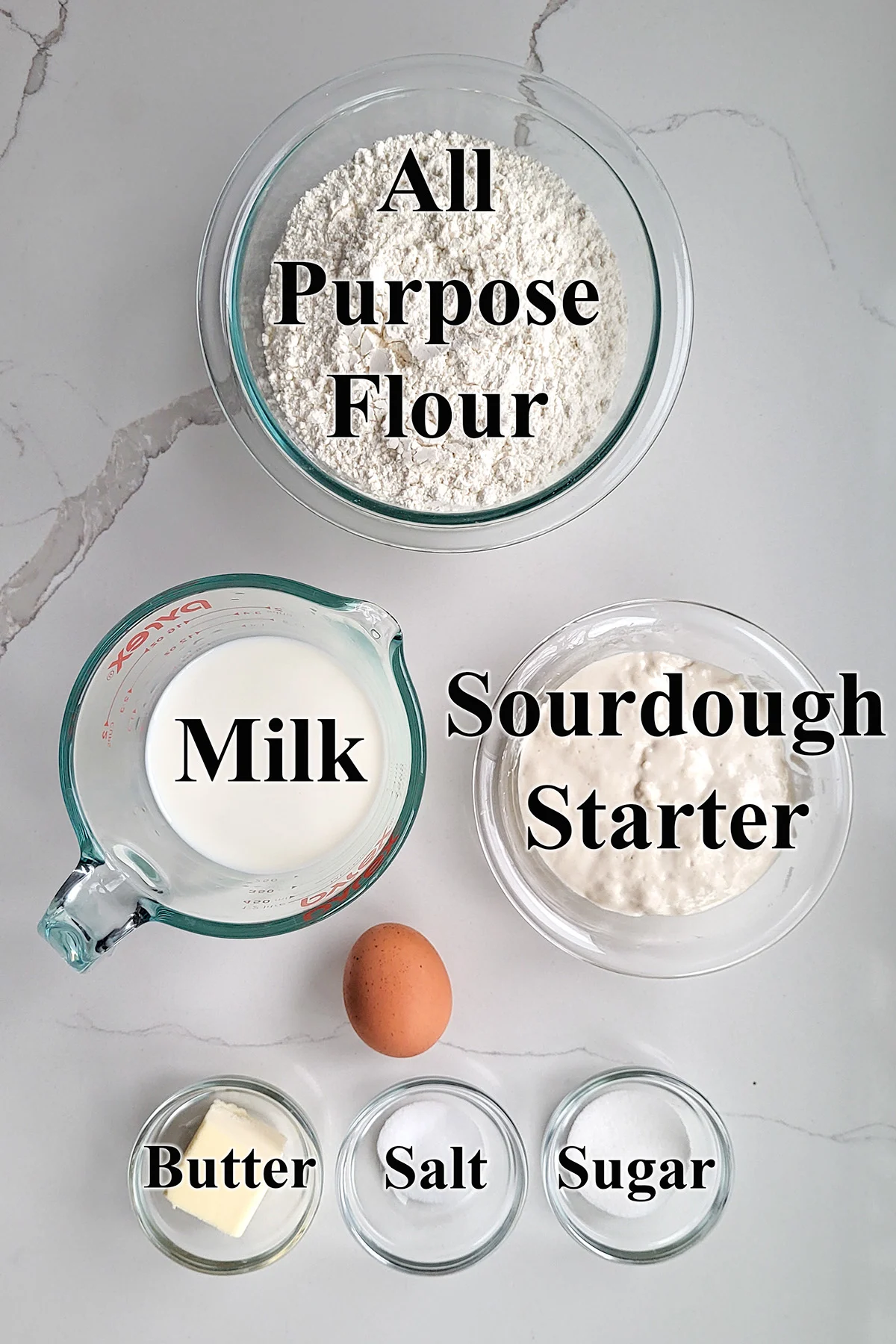 Ingredients for sourdough sandwich bread in glass bowls.