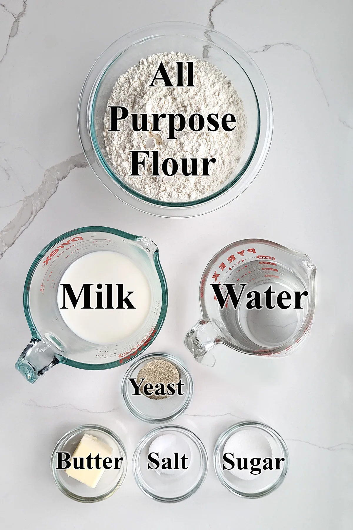 Ingredients for white bread in glass bowls.