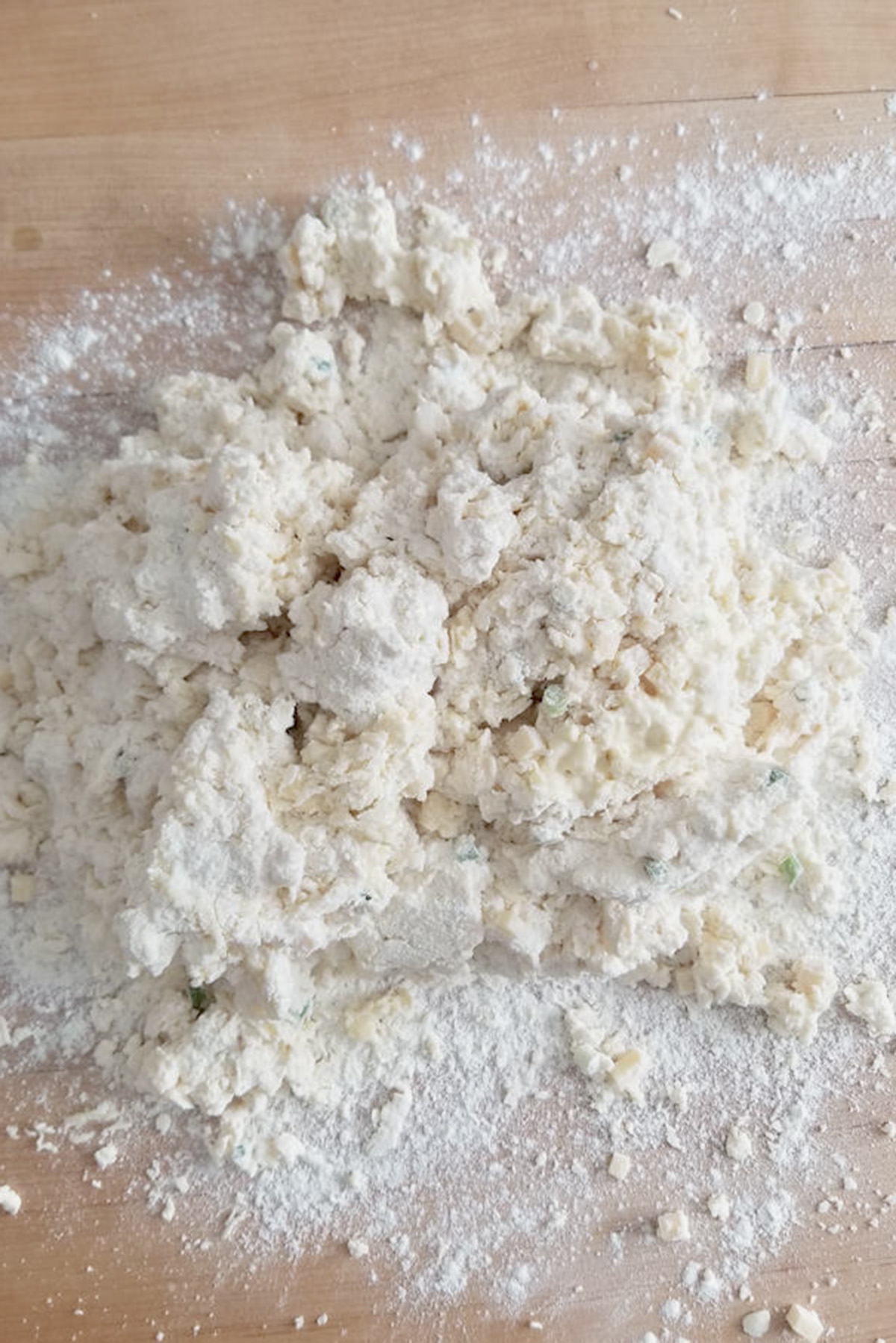 partially mixed scone dough on a wood surface.