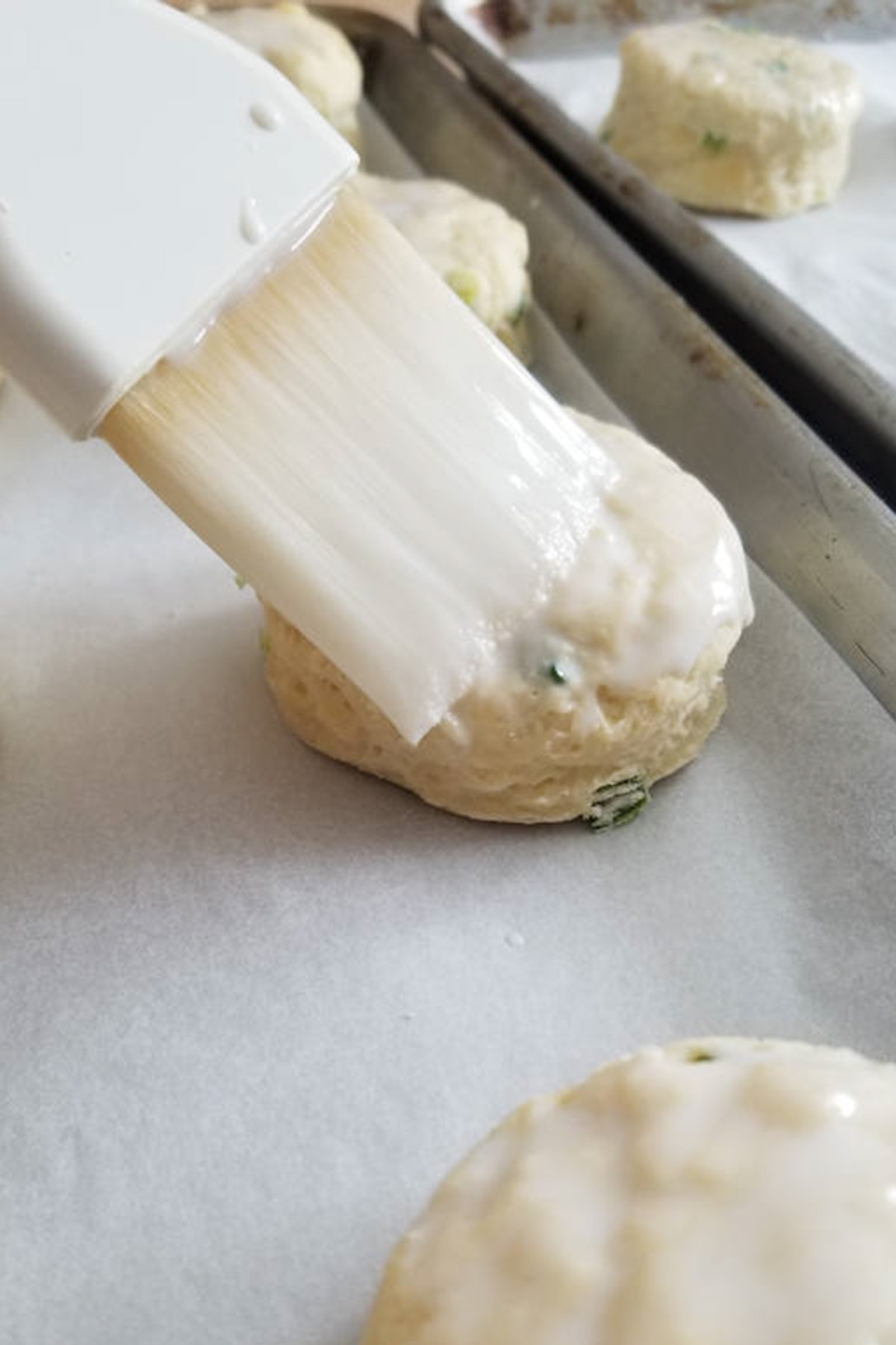 a scone being brushed with buttermilk.