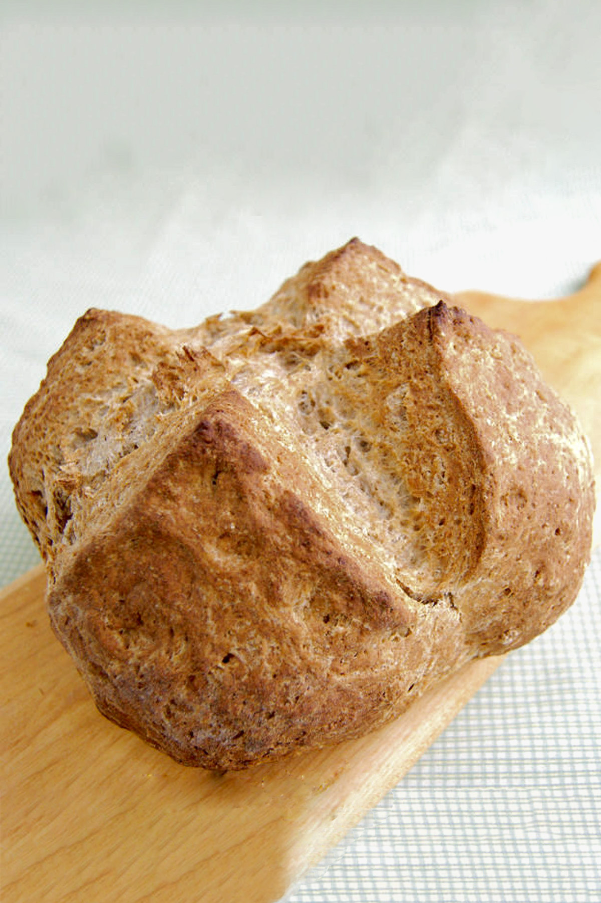 a loaf of irish brown bread on a cutting board.