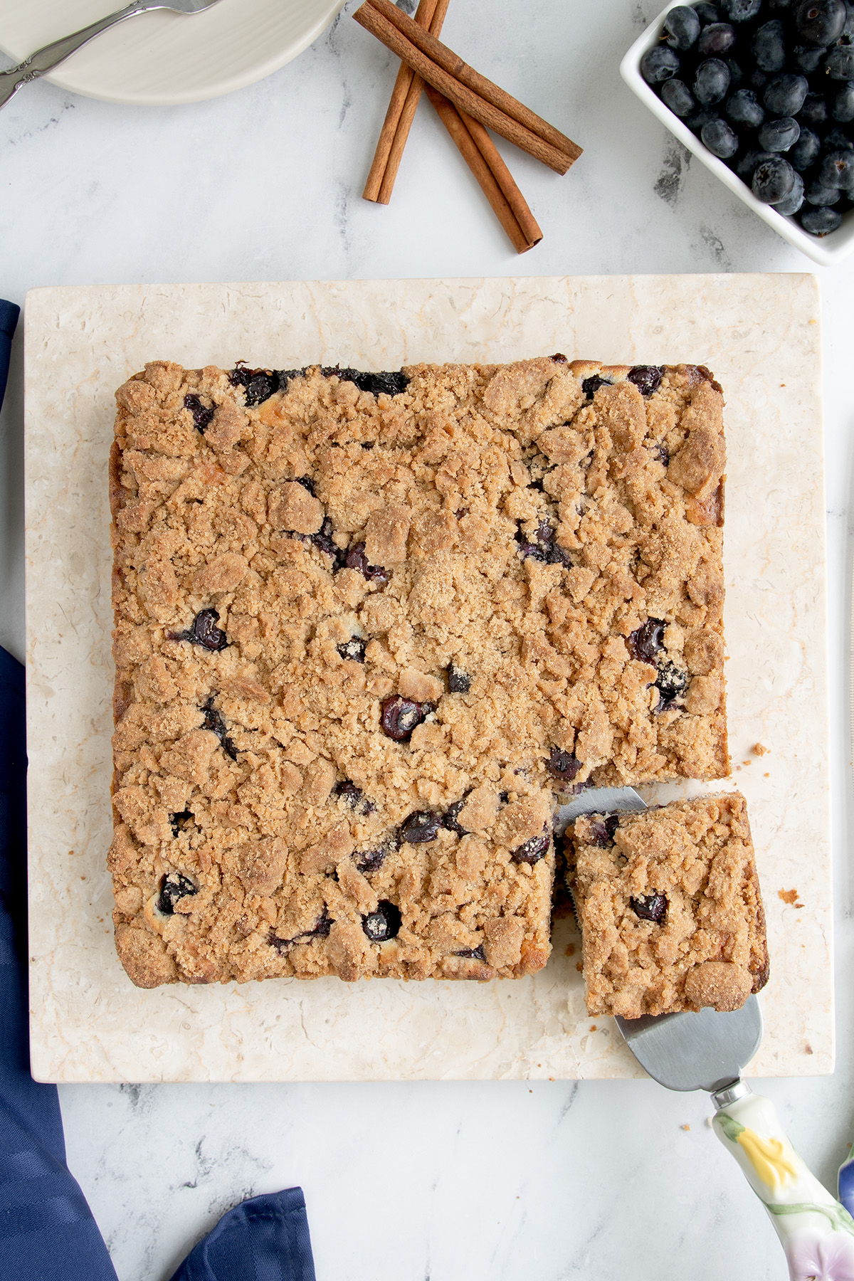 a blueberry coffee cake with a slice cut.