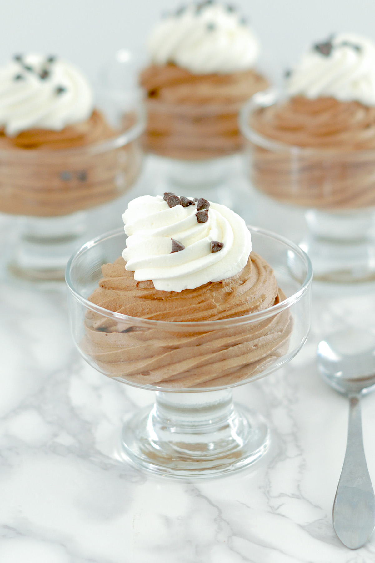 a glass dessert bowl filled with chocolate mousse.