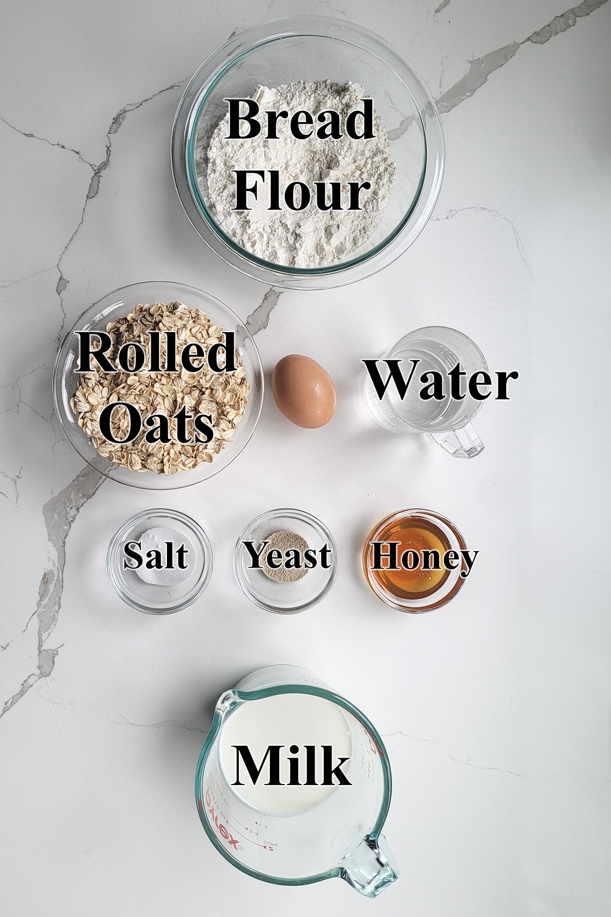 ingredients for honey oatmeal bread in glass bowls.