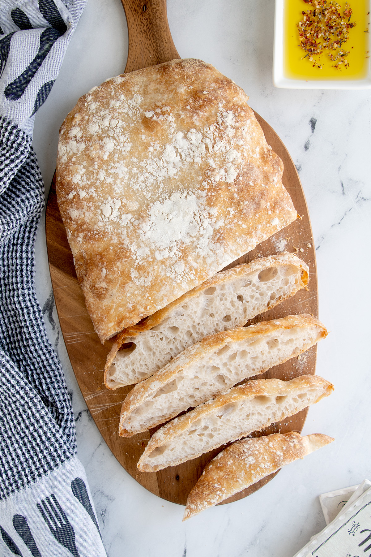 a sliced loaf of ciabatta bread on a cutting board.