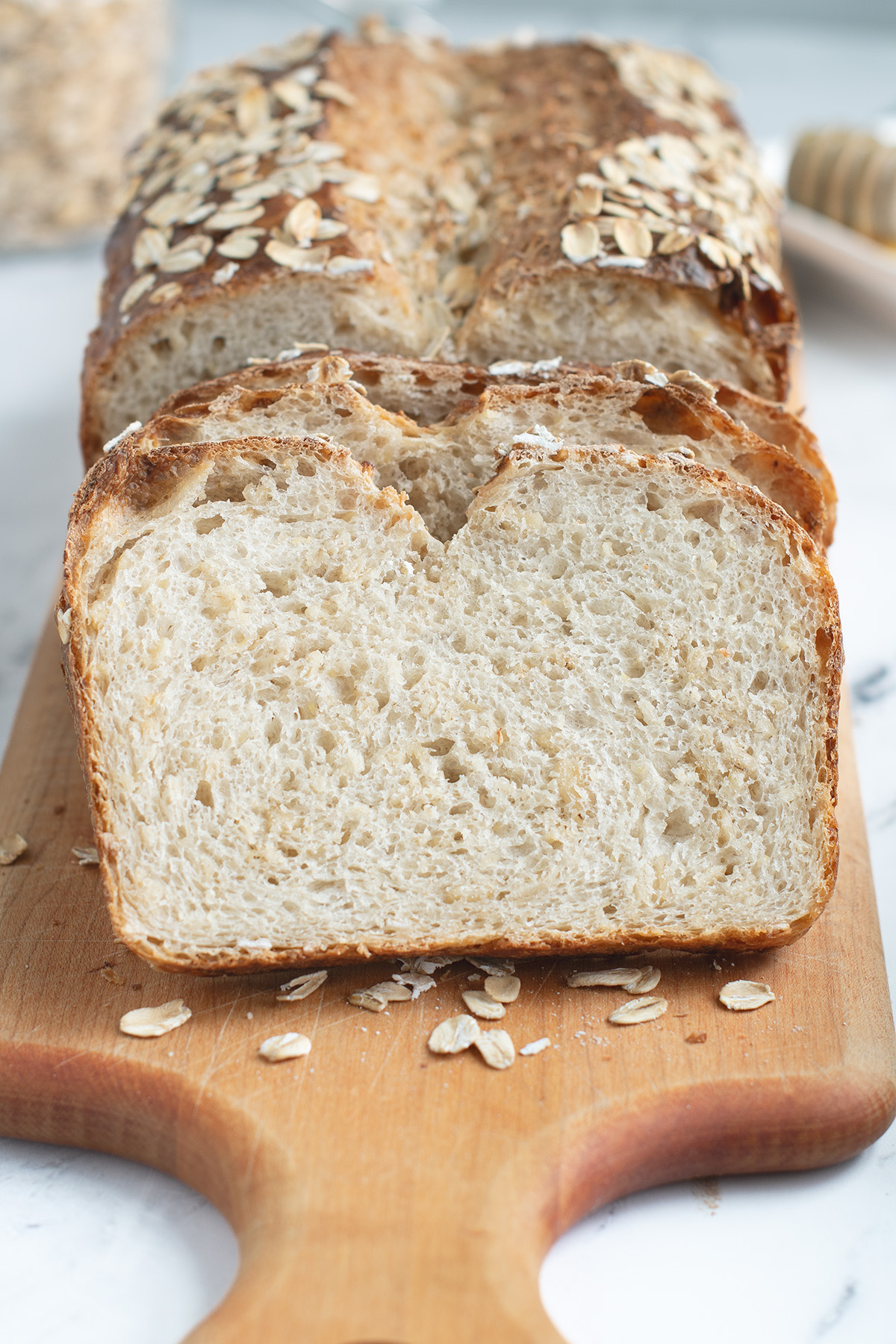 slices of sourdough oatmeal bread on a cutting board.