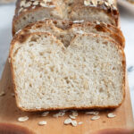 slices of oatmeal sourdough bread on a cutting board.