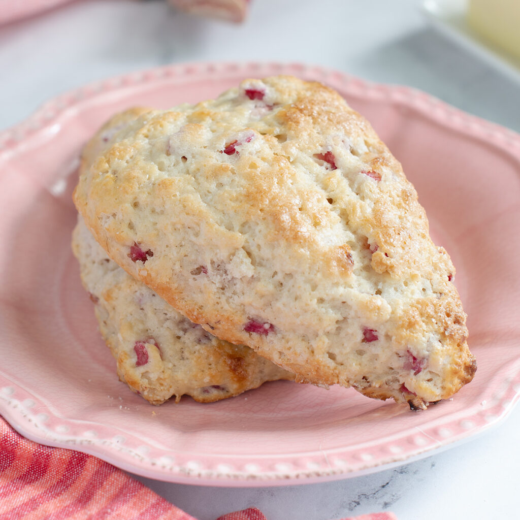 two rhubarb scones on a pink plate.
