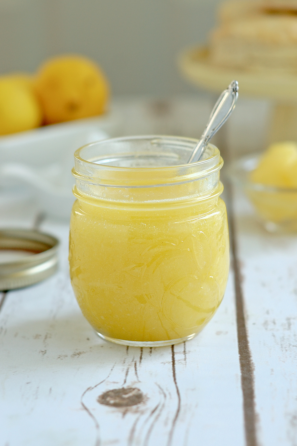 a jar of lemon curd with a spoon in it.