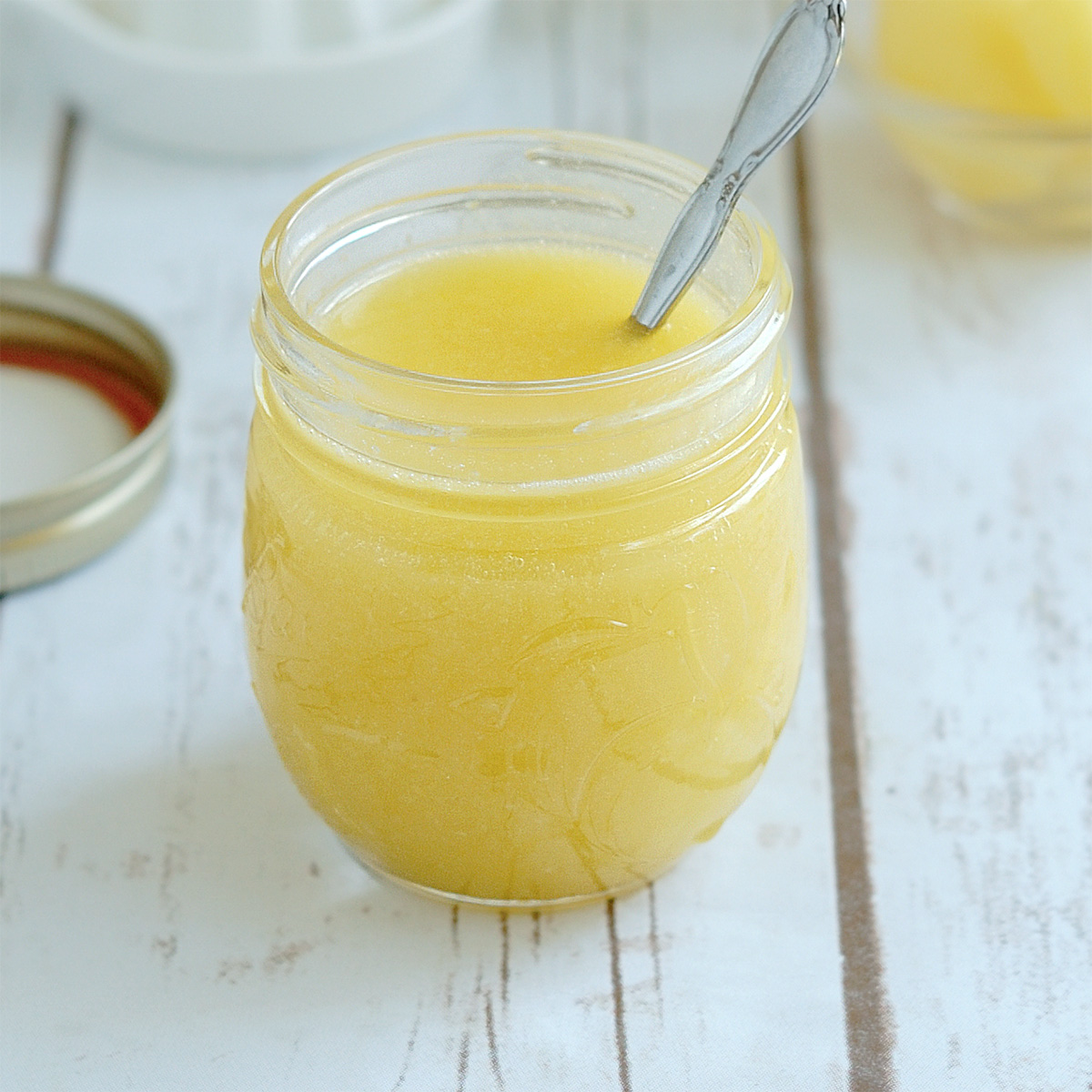 a jar of lemon curd with a spoon.