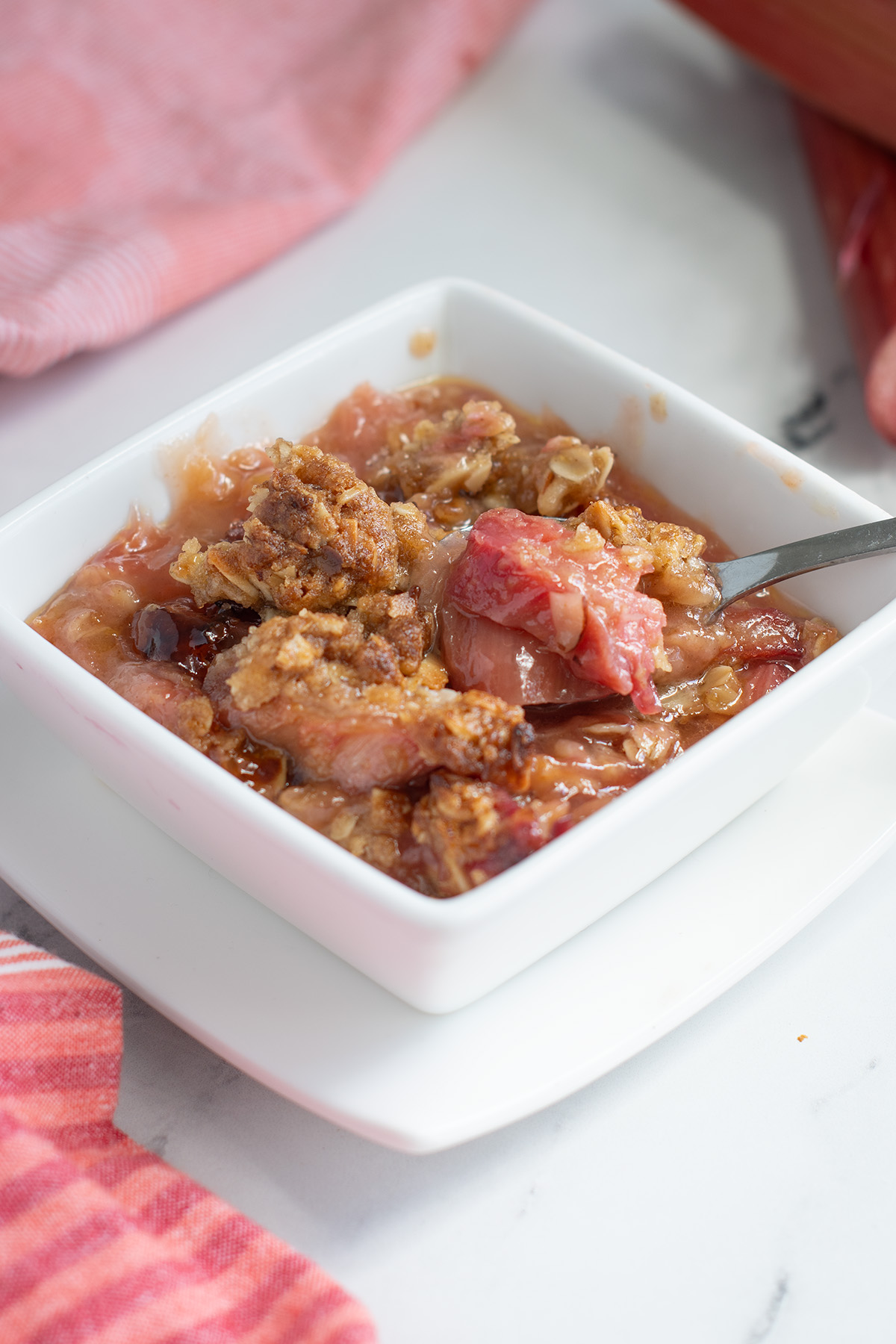 a white bowl filled with rhubarb crisp.