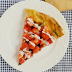 a slice of fruit topped pizza on a white plate.