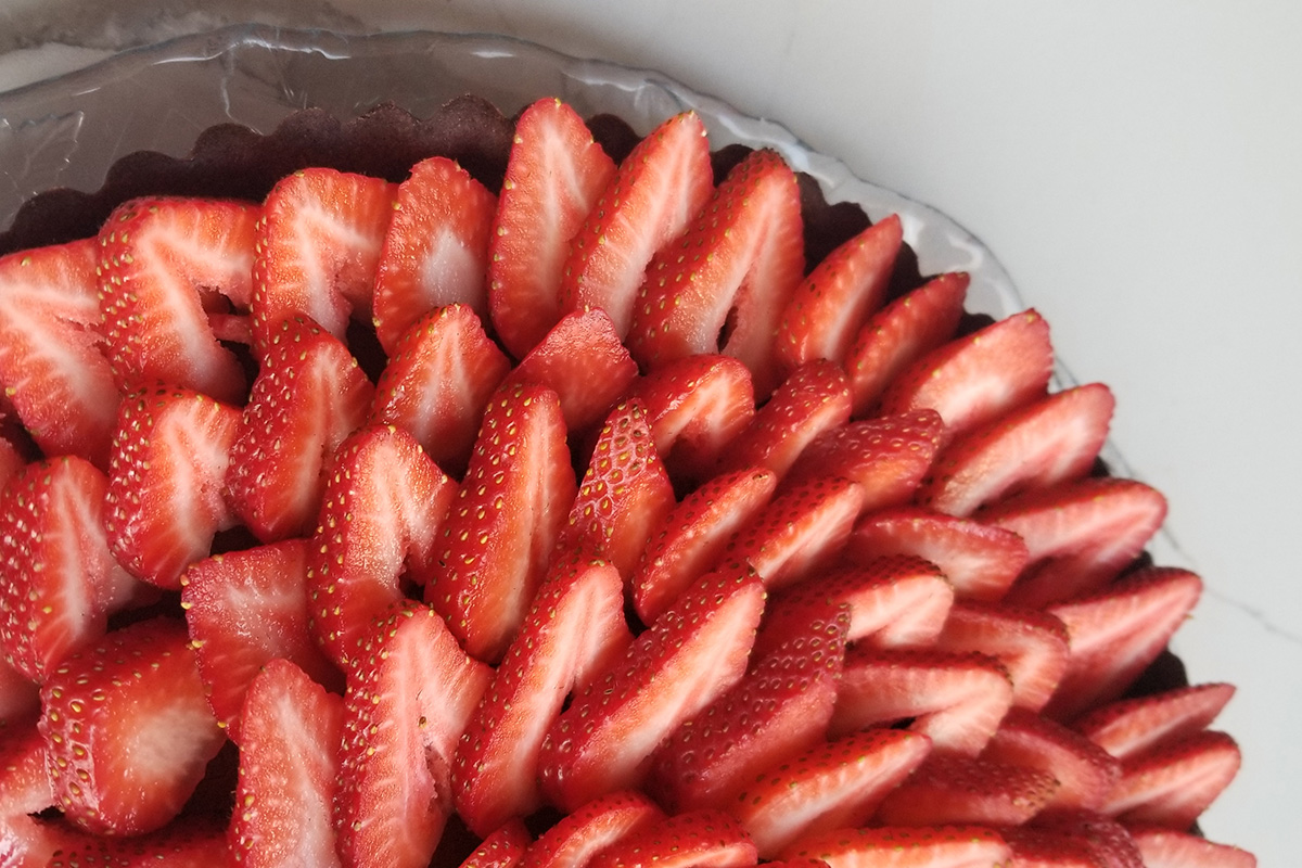 a closeup of sliced strawberries on a tart.