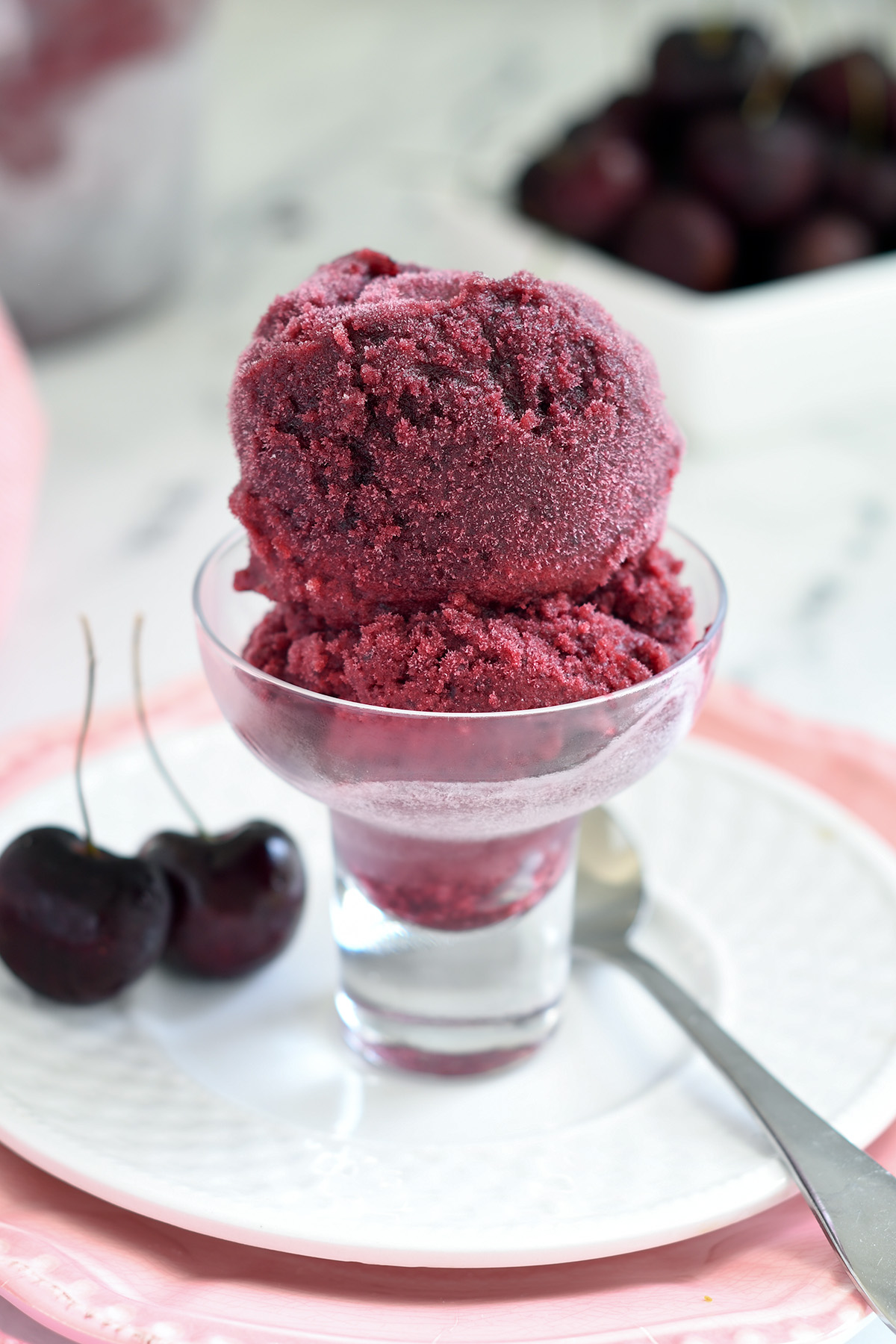 a glass bowl filled with cherry sorbet. 