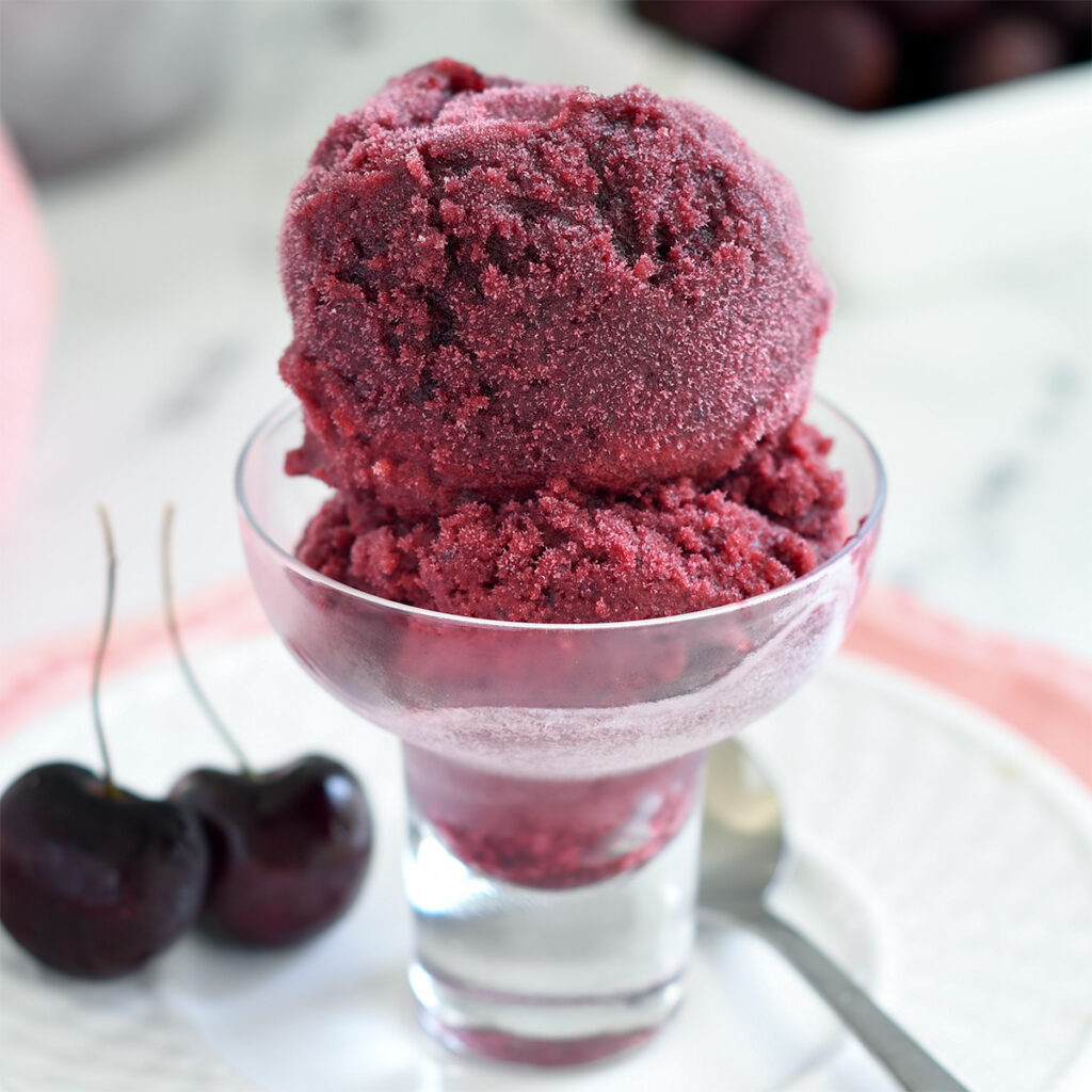 a glass bowl filled with cherry sorbet.
