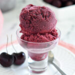 a glass bowl filled with cherry sorbet.