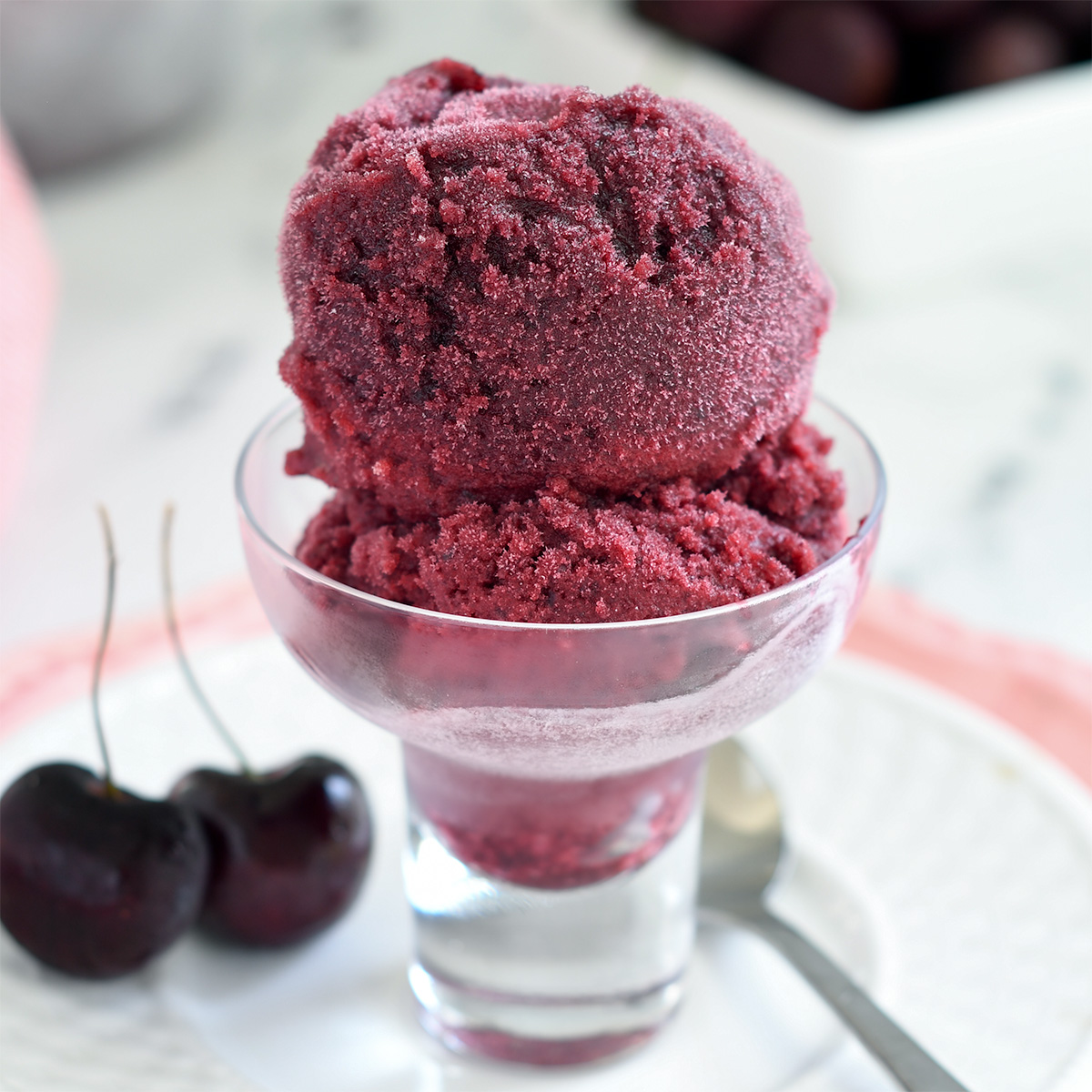 a glass bowl filled with cherry sorbet.
