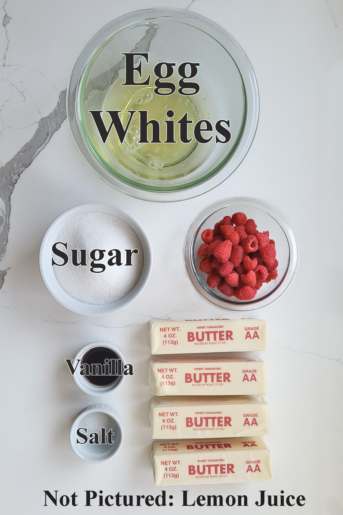 ingredients for raspberry meringue buttercream in glass bowls on a white surface. 