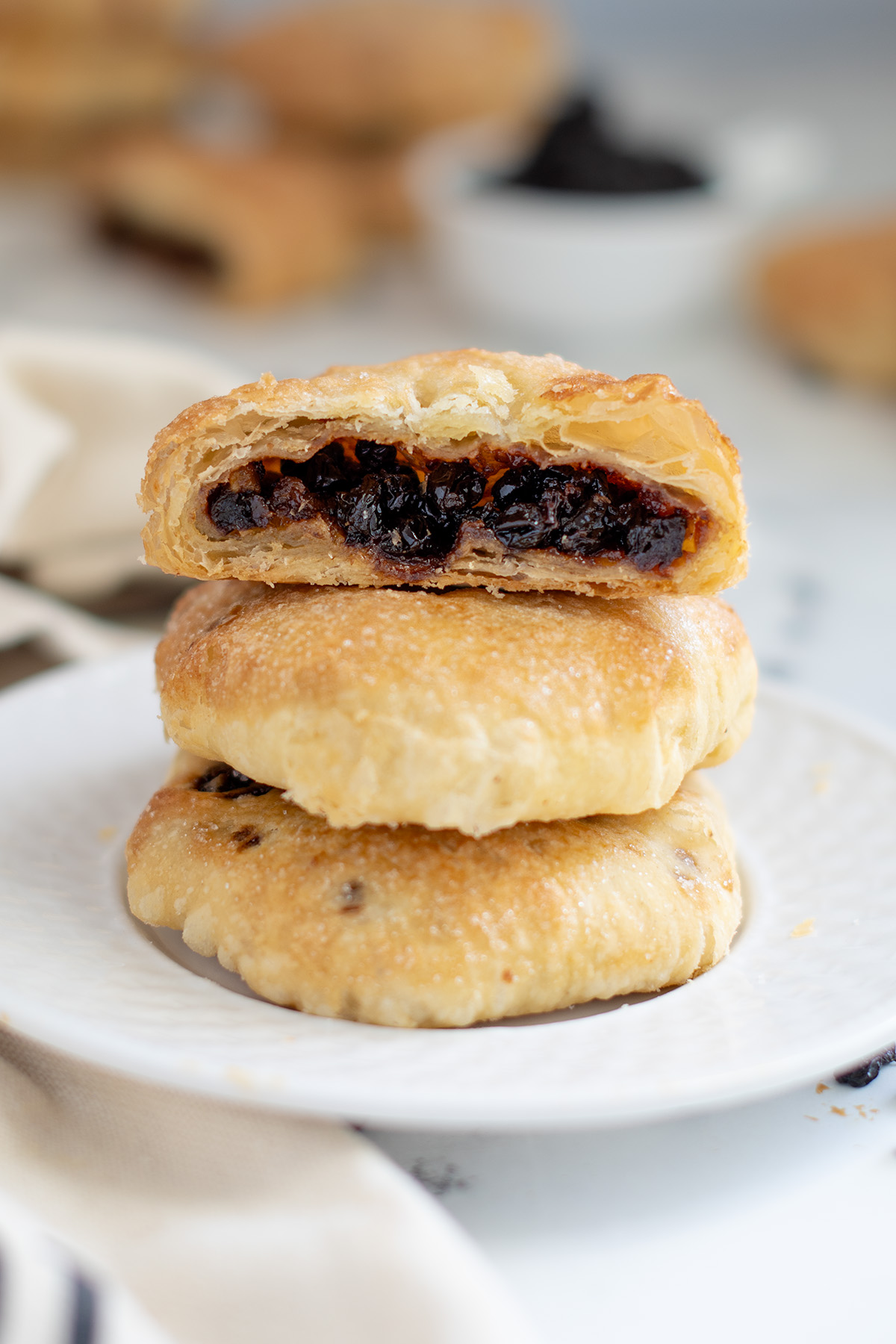 a stack of eccles cakes on a white plate.