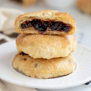 a stack of eccles cakes on a white plate.