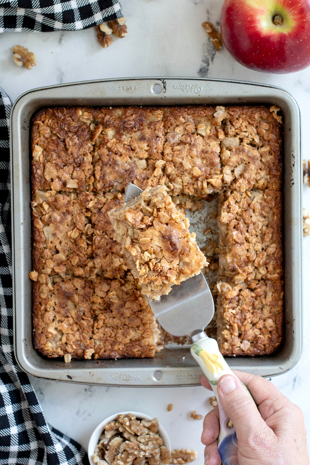 a pan of sourdough baked oatmeal with a serving on a spatula.