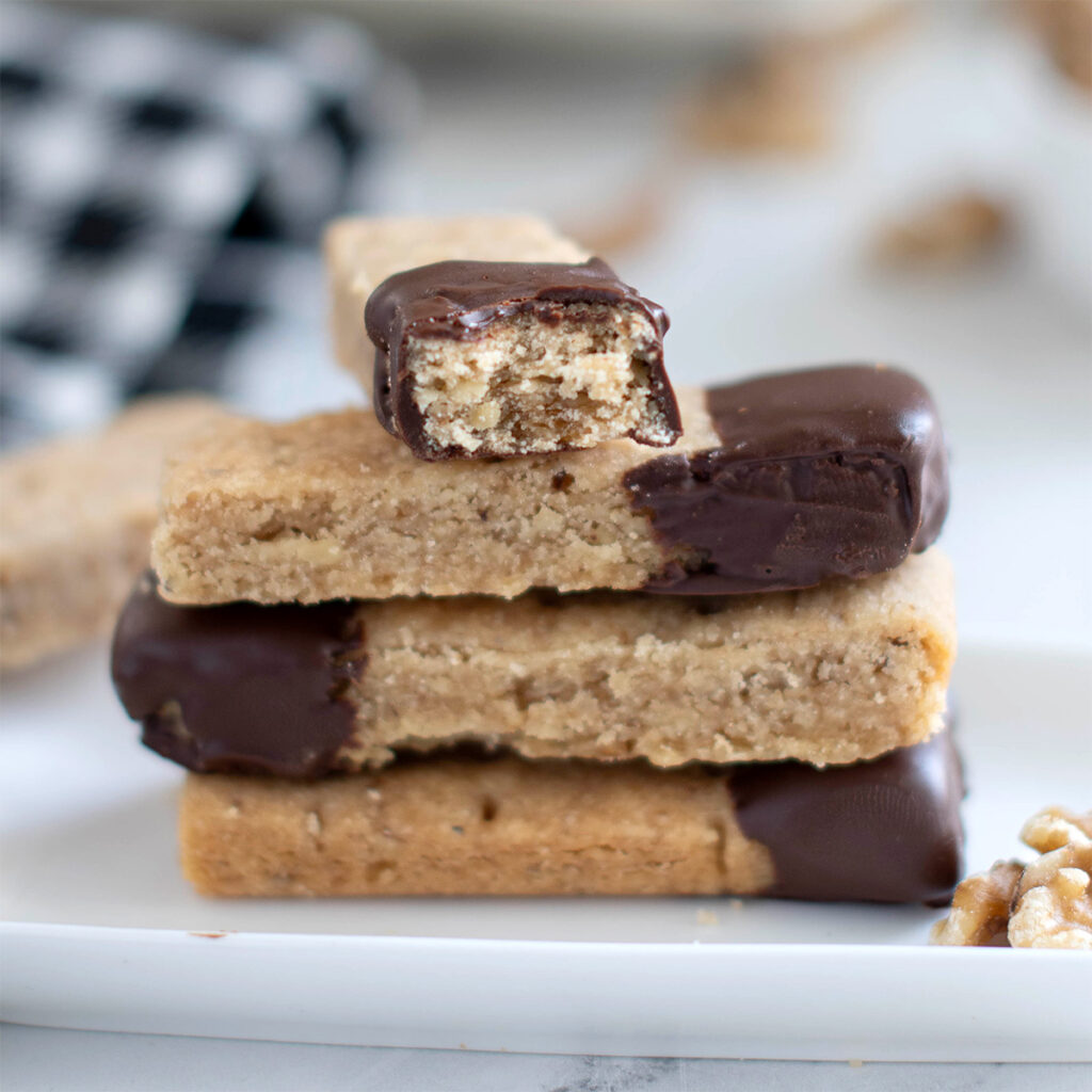 a stack of walnut shortbread cookies on a white plate.